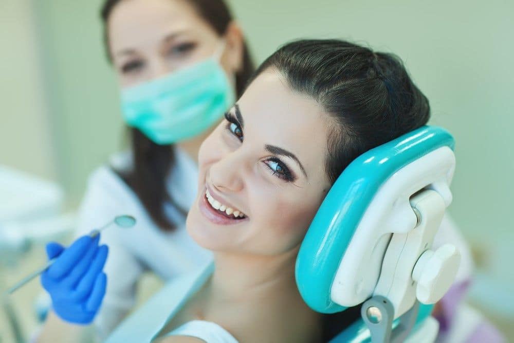 Young woman smiling after deep cleaning treatment in Long Beach, CA